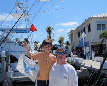 Kid with dad holding a blue marlin flag